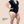 A model wearing a black short-sleeve V-neck top and and Hem Support Wear's High Waisted Brief prolapse support underwear in black. Text in the lower left corner reads 'Model Height: 5' 9